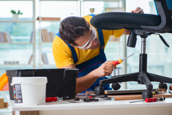 This is a picture of a man fixing an office chair.